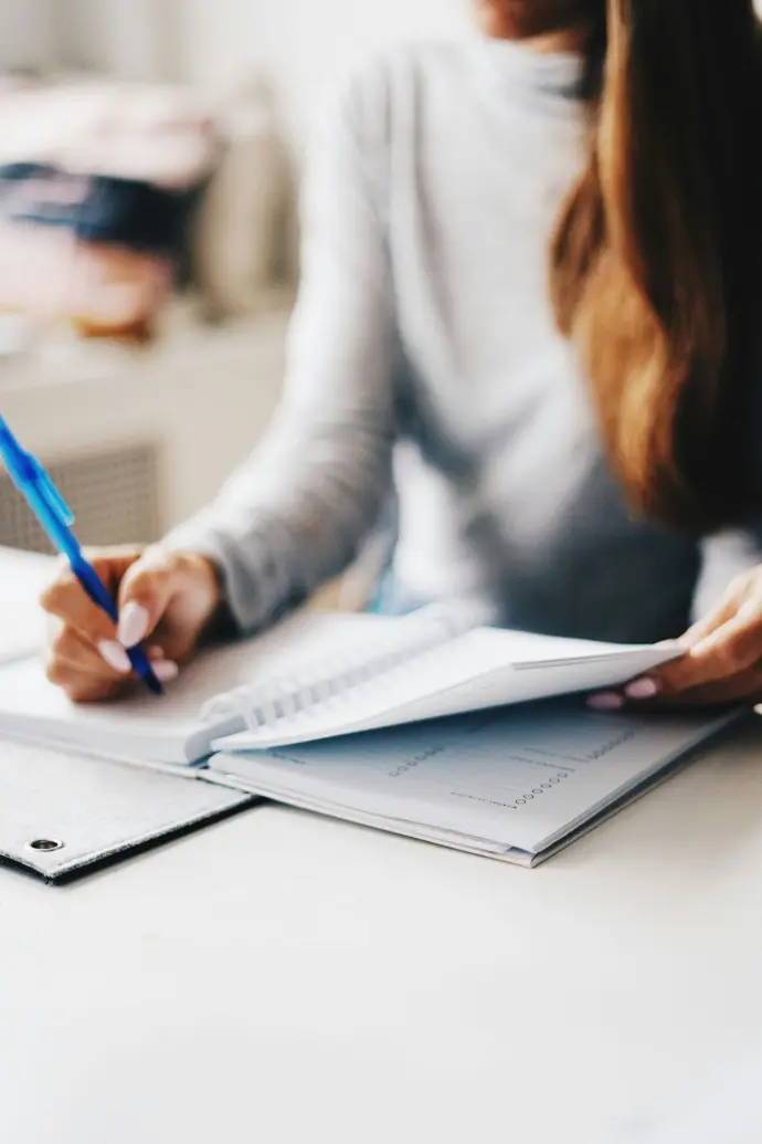 Personne en train d'écrire dans un carnet de notes